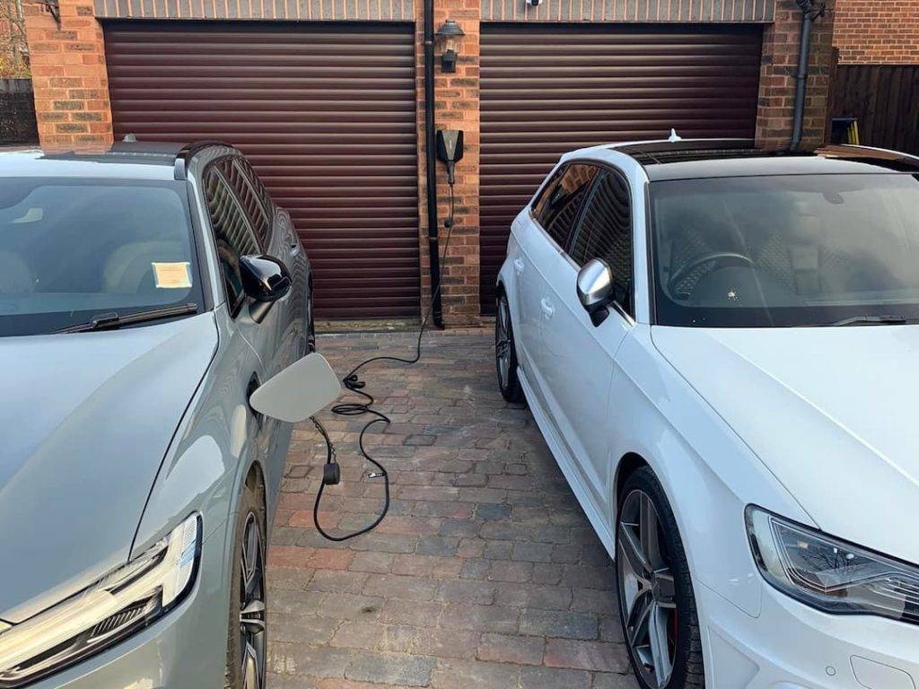 Two Electric Cars Parked On A Driveway